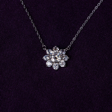 Veyelle Neve moissanite snowflake necklace in white gold on plum velvet background