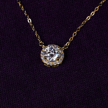 Veyelle Lumière moissanite station necklace in golden gold on plum velvet background