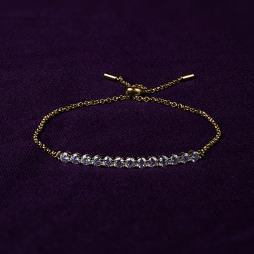 Veyelle Demi moissanite station bracelet in golden gold on plum velvet background