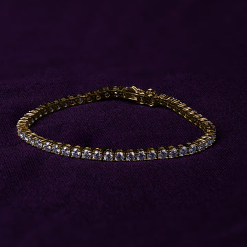 Veyelle Éclat moissanite tennis bracelet in golden gold on plum velvet background