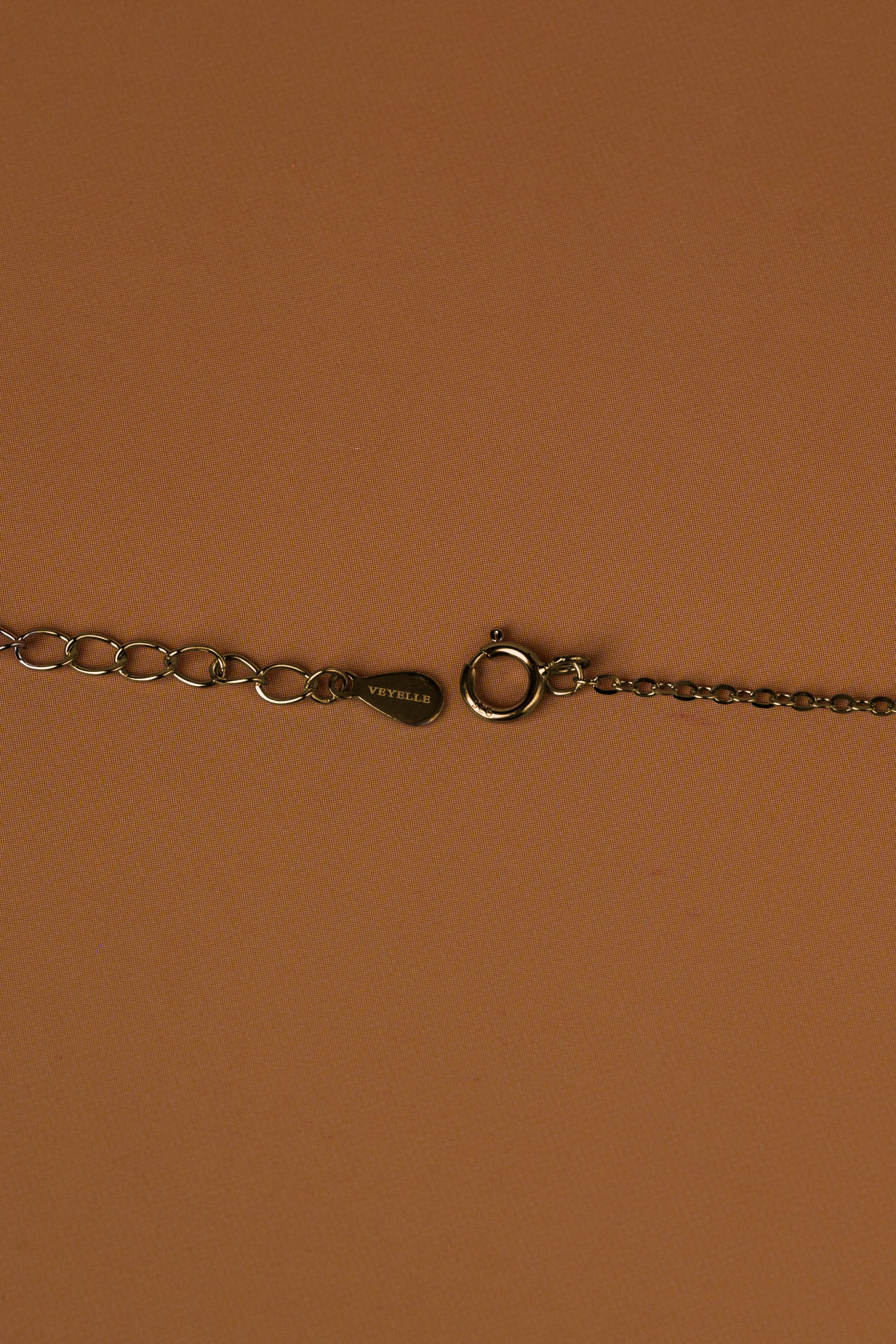 Veyelle necklace clasp detail showing Veyelle logo and lobster clasp in golden gold